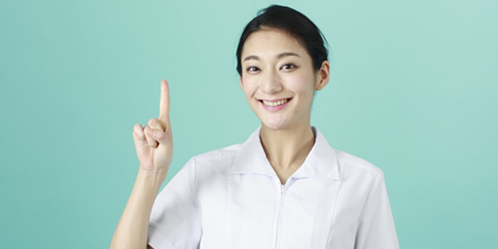 女性看護師が笑顔で人差し指を立てている画像